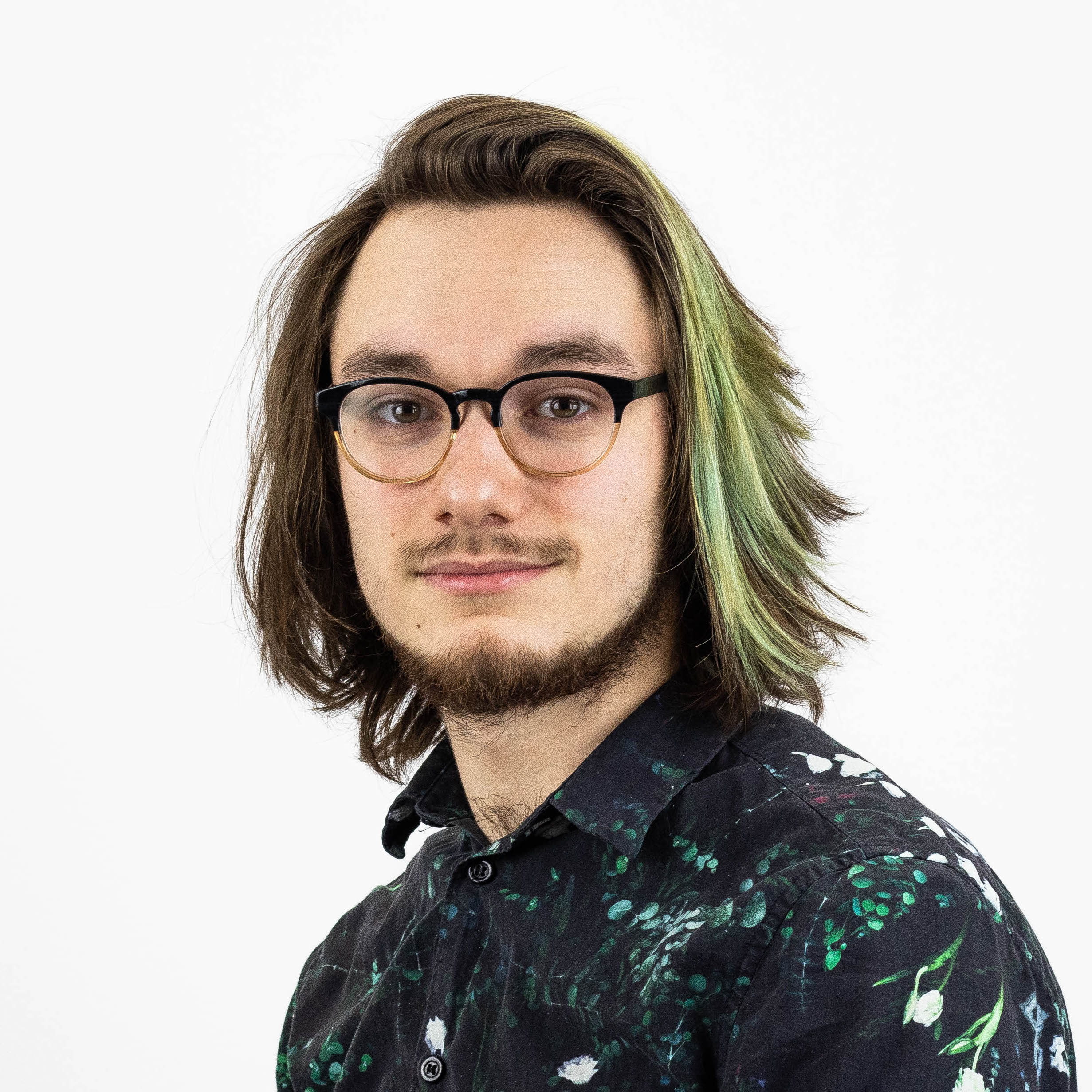 Headshot, white background. Caucasian with medium-length hair and a slight beard.